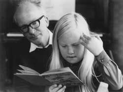 A photograph of Leslie Duffen watching his daughter Sarah read a book